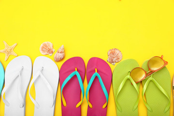 Flat lay composition with different flip flops on yellow background, space for text. Summer beach accessories