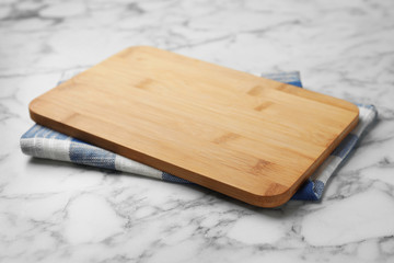 Wooden board and kitchen towel on marble table