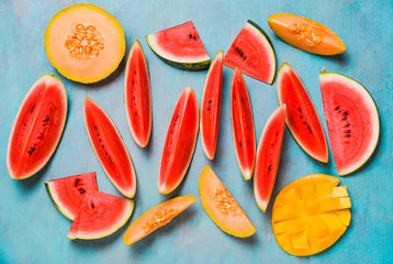 Summer fruits colorful background. Watermelon and melon slices on turquoise background.