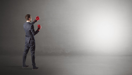 Businessman fighting with boxing gloves in an empty space