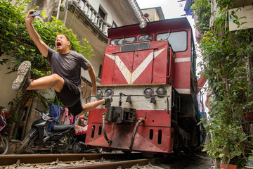Man with mobile phone makes dangerously selfie photo in front of moving train. An undisciplined...