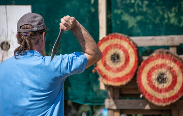 A man is ready for throwing knife on competition.