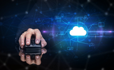 Hand using wireless mouse in a dark environment with cloud technology and online storage concept