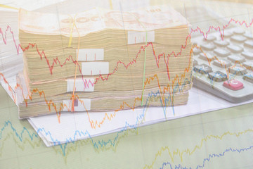 double exposure stock market line graph for analyze and Thai money currency and calculator on table for analyze.