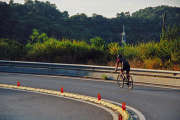 Cyclist driving down a road on the mountain.