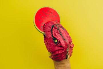 Naklejka premium toy rubber hand dinosaur eating watermelon