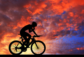Obraz premium Sylwetka na rowerze na tle rozmyte niebo wschód słońca