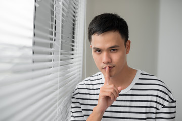 Fototapeta na wymiar Attractive man with finger on lips making silence gesture. Shh!!!