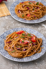 Udon stir fry noodles with vegetables in plate with chopsticks