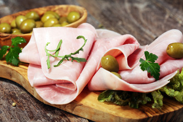 Sliced ham on wooden background. Fresh prosciutto. Pork ham proscuitto sliced.