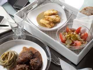 Platos en bandeja, ensalada, carne y pescado rebozado., vista cenital. Dishes on a tray, salad, meat and fish in batter, overhead view