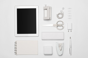 Mix of office supplies and gadgets on white background