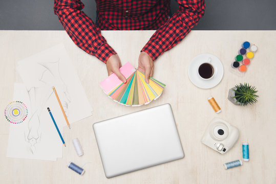 Top view of male fashion designer is showing or finding color at his office table.