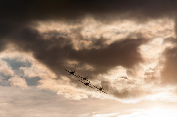 Aerobatics planes flying in the sky with clouds in the background