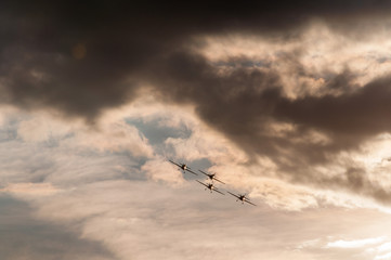 Aerobatics planes flying in the sky with clouds in the background