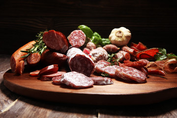 Food tray with cold meat with delicious salami and herbs . Variety of meat products including coppa and sausages