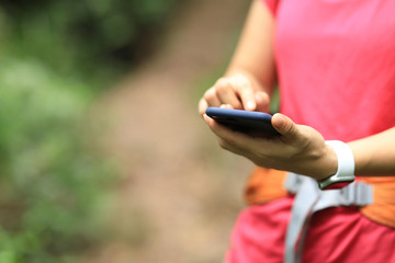 Woman hiker using smartphone on hiking travel