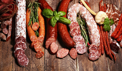 cold meat assortment with delicious salami and  fresh herbs . Variety of meat products including coppa and sausages