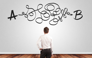Businessman looking for connection between two things while standing in front of a wall