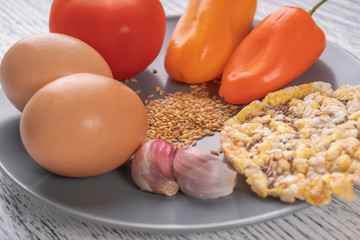 garlic, pepper, tomato, flax seeds, chicken eggs, corn tortillas on a gray plate