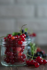 Red currant on dark wooden table in a glass jar