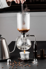 Syphon alternative method of making coffee. coffeemaker is a manual pour-over style glass. Cofee brewing on black background
