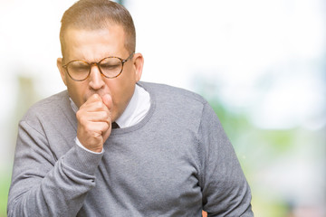 Middle age bussines arab man wearing glasses over isolated background feeling unwell and coughing as symptom for cold or bronchitis. Healthcare concept.