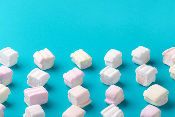Sweet marshmallows on blue background. Minimalism concept, mock up