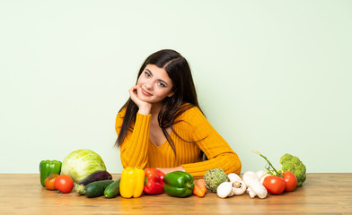 Fototapeta premium Teenager girl with many vegetables smiling