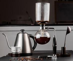 Syphon alternative method of making coffee. coffeemaker is a manual pour-over style glass. Cofee brewing on black background