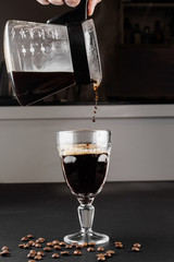 Alternative method of making coffee. coffeemaker is a manual pour-over style glass. Cofee brewing on black background