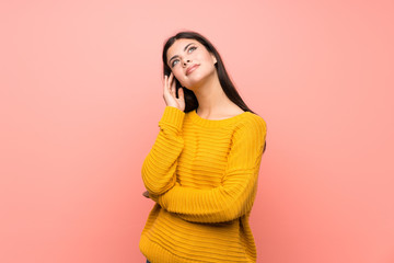 Teenager girl  over isolated pink wall thinking an idea