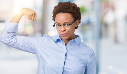 Young beautiful african american business woman over isolated background Strong person showing arm muscle, confident and proud of power