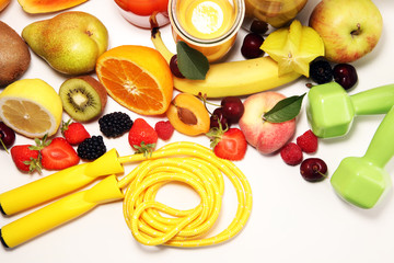 Healthy lifestyle concept. healthy fruits, smoothies and sport fitness equipment, dumbbells and jumping rope
