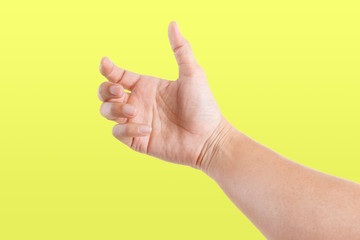 Male asian hand gestures isolated over the yellow background. GRAB POSE.