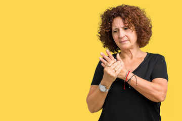 Beautiful middle ager senior woman over isolated background Suffering pain on hands and fingers,...