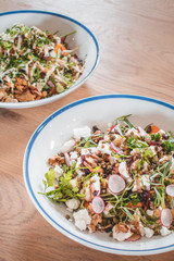 Delicious caesar salad and goatcheese salad on wooden table