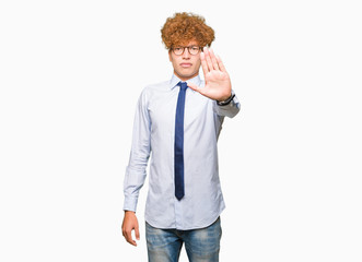 Young handsome business man with afro wearing glasses doing stop sing with palm of the hand. Warning expression with negative and serious gesture on the face.