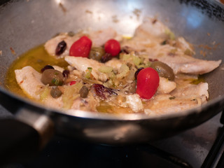 Sautéed cod with tomato, raisins, pine nuts, celery, red onion, oil, pepper and olives and olives