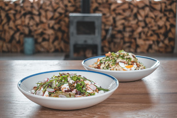 Delicious caesar salad and goatcheese salad on wooden table