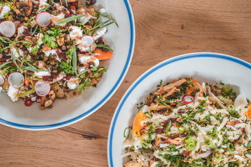 Delicious caesar salad and goatcheese salad on wooden table