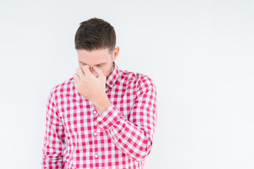 Fototapeta premium Young handsome man wearing shirt over isolated background tired rubbing nose and eyes feeling fatigue and headache. Stress and frustration concept.