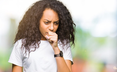 Fototapeta na wymiar Young beautiful girl with curly hair wearing casual white t-shirt feeling unwell and coughing as symptom for cold or bronchitis. Healthcare concept.