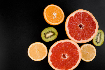 Mix of orange, kiwi, grapefruit on black background. Citrus fruit. Healthy freshness food. Orange fruit with vitamin