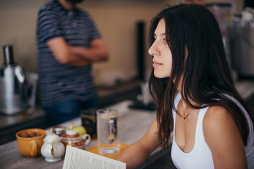 Female with magazine sitting in coffee bar