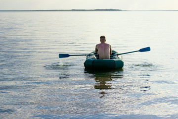  young man sailing on a lake in a boat