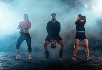 Team workout with kettlebells at fitness gym