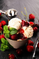 Cherry and vanilla ice cream scoop with fresh cherries and mint on a rustic background