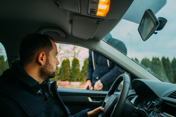 Armed bandit hijacking a middle-aged man's car.
