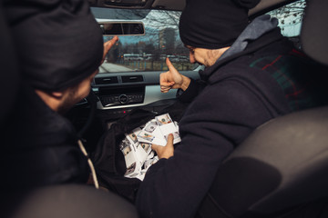 After the successful bank robbery, the thieves are sitting in the car showing off their money and...